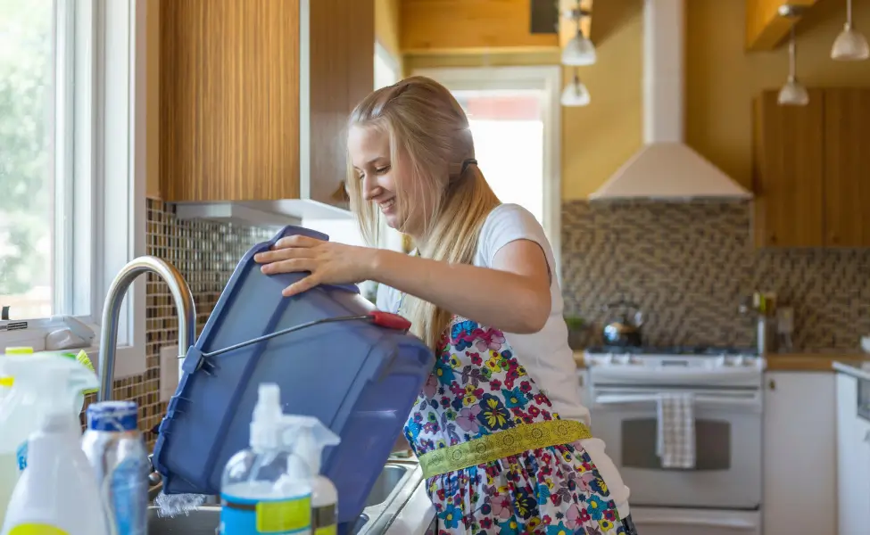 Teen cleaning kitchen with green cleaning products